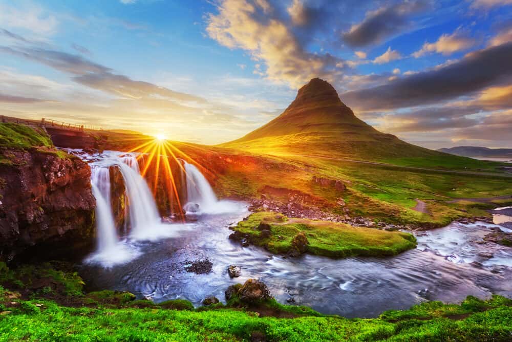 Morning landscape with rising sun on Kirkjufellsfoss waterfall and Kirkjufell mountain, Iceland, Europe.