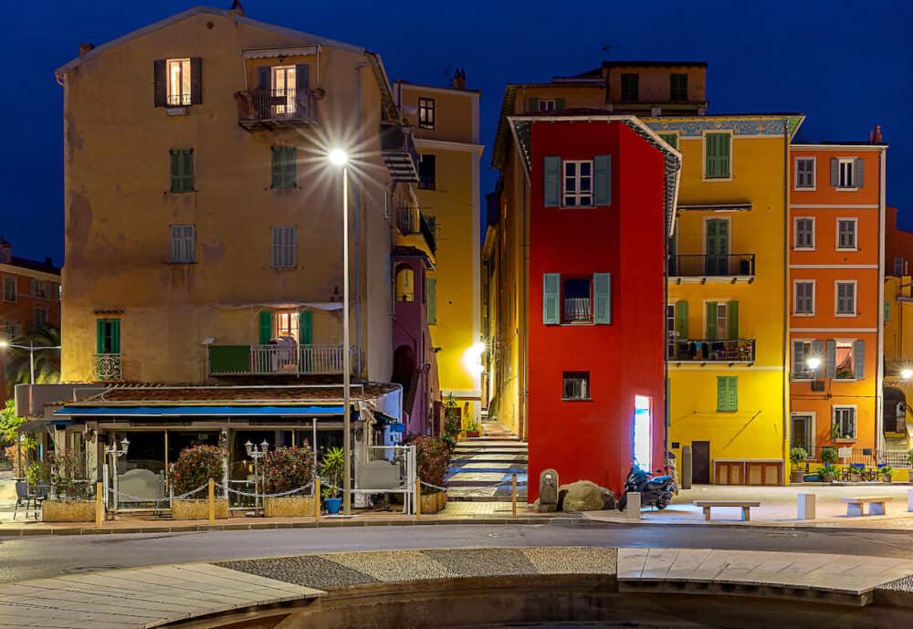 Scenic view of multi-colored medieval houses in the historical part of the city at night. Menton. France.