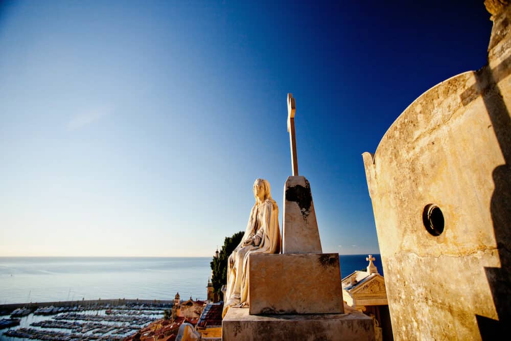 MENTON, FRANCE -  A female statue at the old russian cemetery "Cimetiere du Vieux-Chateau" with view on Mediterranean sea in Menton, France, Cote d'Azur.