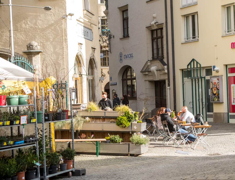 Munich,Germany-People sit outside a cafe in Munich's Viktualienmarkt on a sunny afternoon