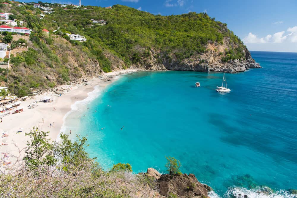 Sea beach with blue water, white sand and mountain landscape in gustavia, st.barts. Summer vacation on tropical beach. Recreation, leisure and relax concept. Wanderlust and travel with adventure