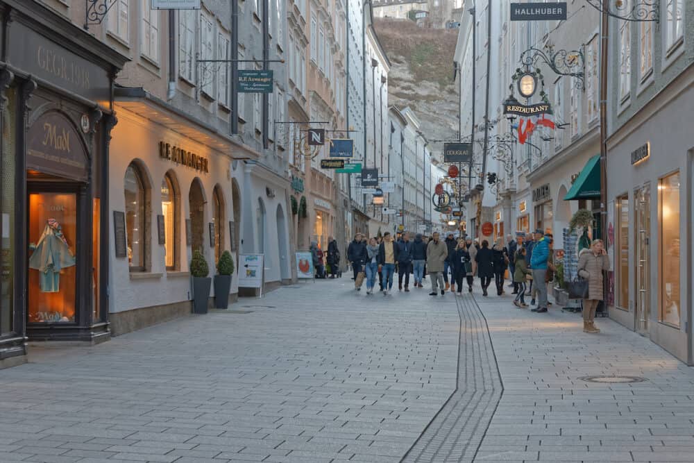 SALZBURG, AUSTRIA, Tourists walking and sightseeing popular shopping street Getreidegasse in city center.