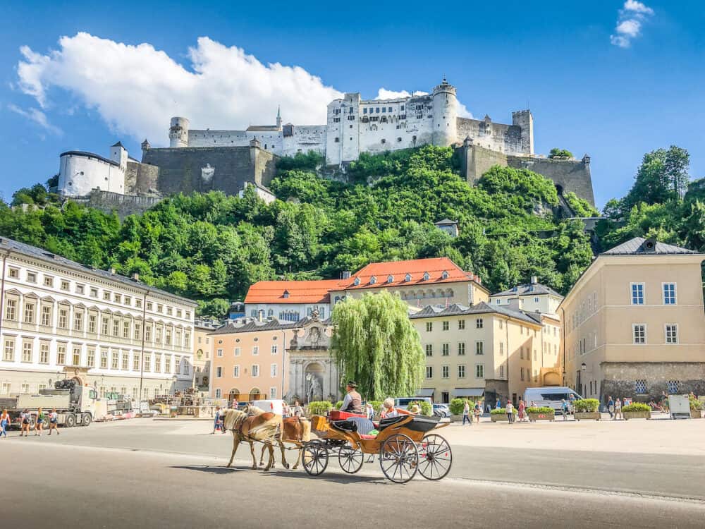 Beautiful Panoramic View Of The Historic City Of Salzburg With Traditonal Horse-drawn Fiaker Carriag