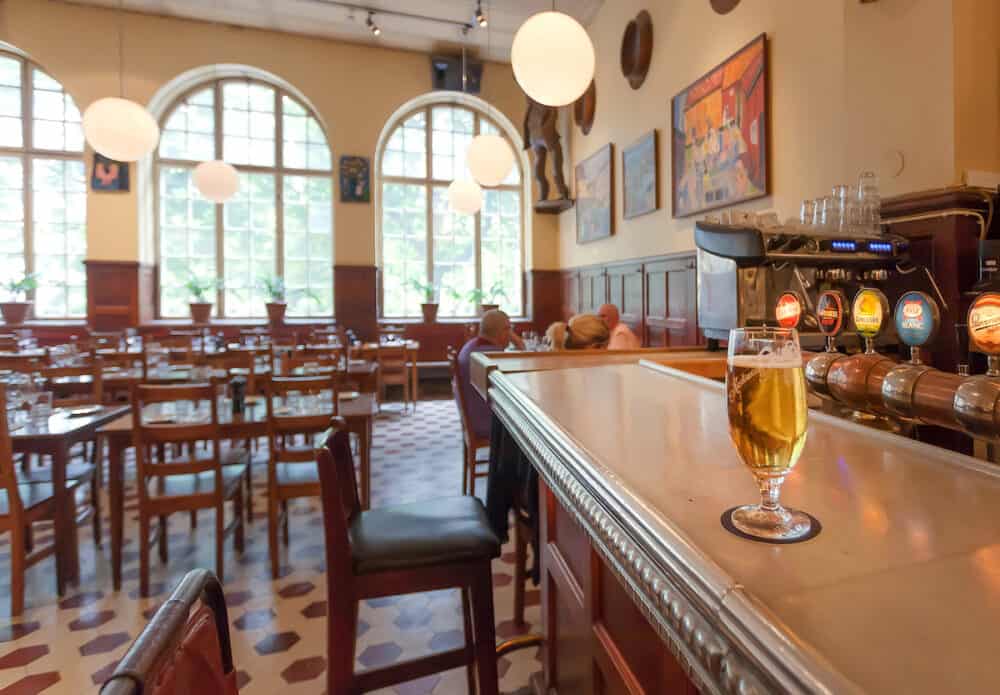 STOCKHOLM, SWEDEN - Glass of beer on bar counter of the famous restaurant Kvarnen with vintage furniture. Sweden with 10,5 million people ranks high in life expectancy