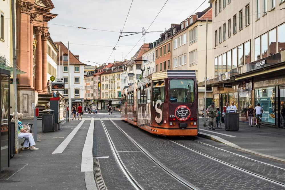 Wurzburg Germany -  An electric tram and people on foot in a street in the city center of Wurzburg Bavaria Germany.