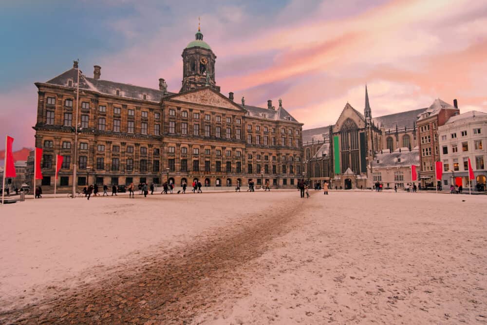 Snowy Dam square in Amsterdam the Netherlands in winter at sunset