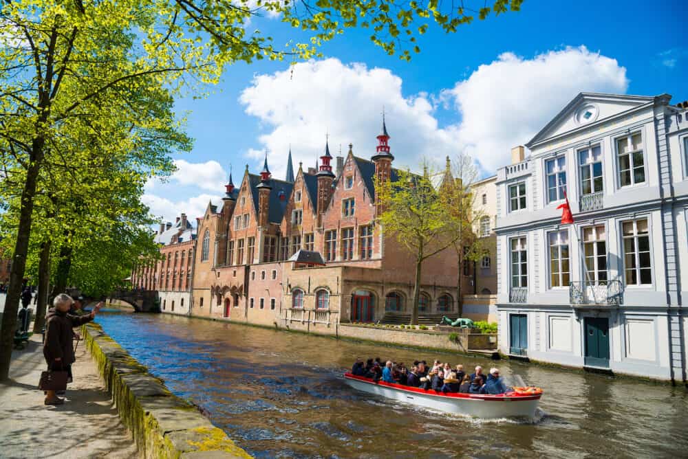 Bruges, Belgium - Tourist boat on canal in Bruges in a beautiful summer day, Belgium