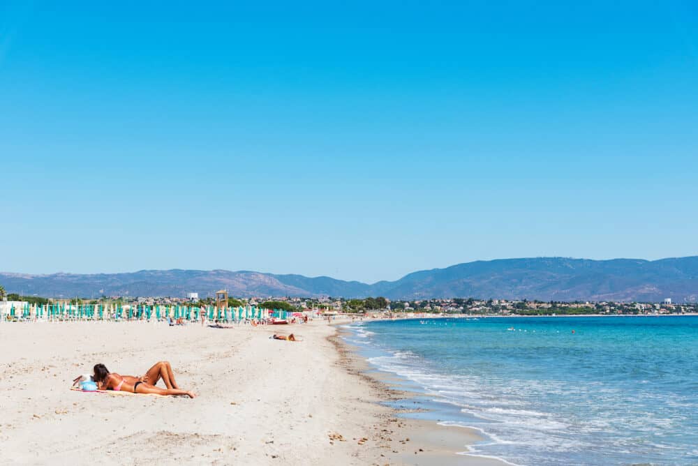 CAGLIARI, ITALY - People sunbathing on the Spiaggia del Poetto beach in Cagliari, Sardinia, Italy