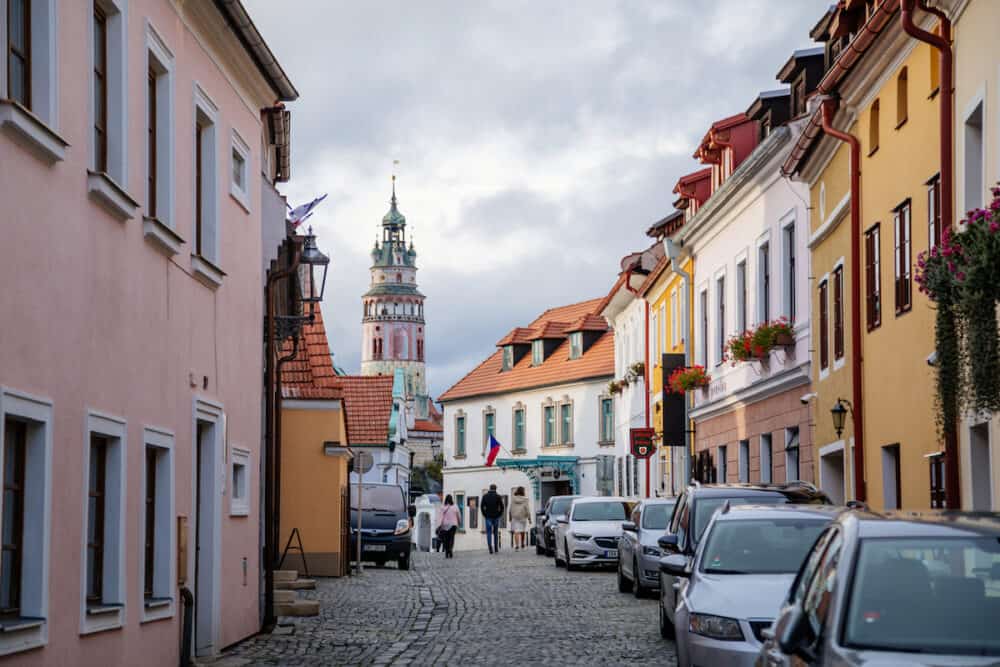 Narrow street with colorful historical buildings, view of the castle tower and city theater in the center of Cesky Krumlov, South Bohemia, Czech Republic