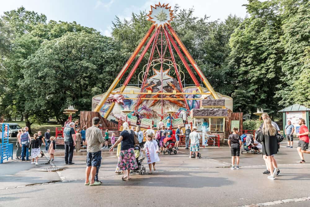 People in front of the Swinging ship in the amusement park Bakken, Copenhagen