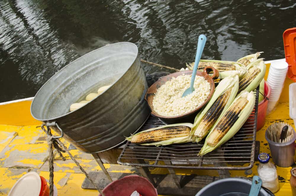 Esquites and elotes, traditional Mexican corn-based meals, in a Trajinera boat that runs along the Xochimilco canals selling to visitors