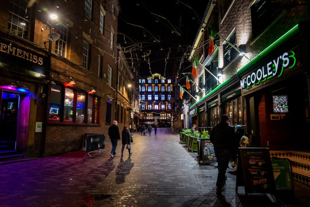 LIVERPOOL, ENGLAND, People enjoying a pleasant night time in historic Matthew Street in Liverpool with a mixture of several colours of light from the bars and restaurants around