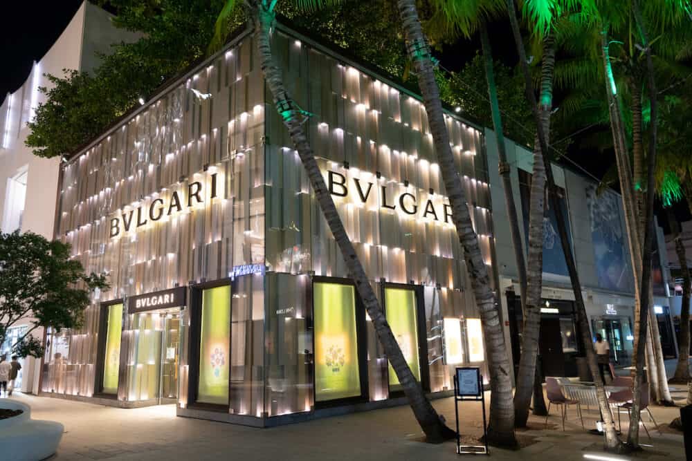 Miami, USA -  Bulgari or bvlgari shop corner and palm trees at night street of design district in Florida