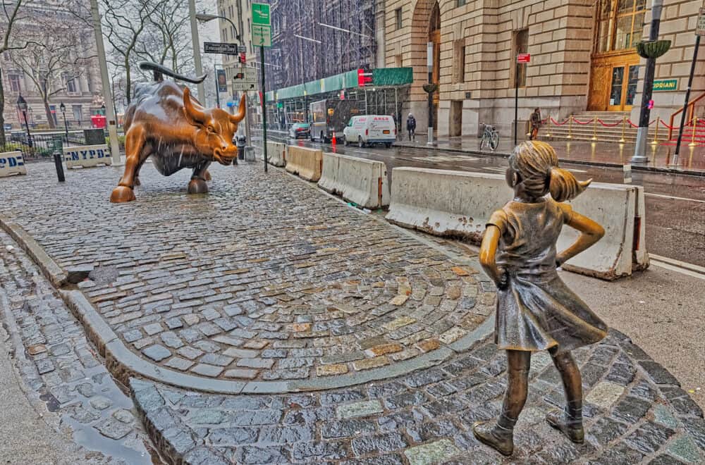 NEW YORK, USA - The Fearless Girl statue facing Charging Bull in Lower Manhattan in a cold winter day while snowing.