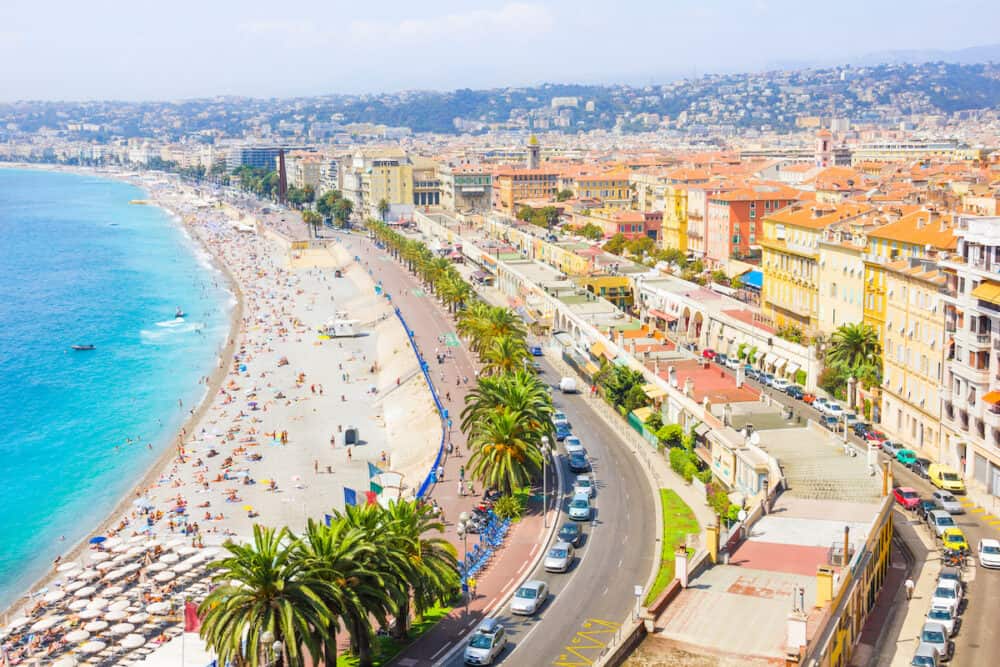 NICE, FRANCE - Tourists enjoy the good weather at the beach in Nice, France. The beach and the waterfront avenue, Promenade des Anglais, are full almost all the year.