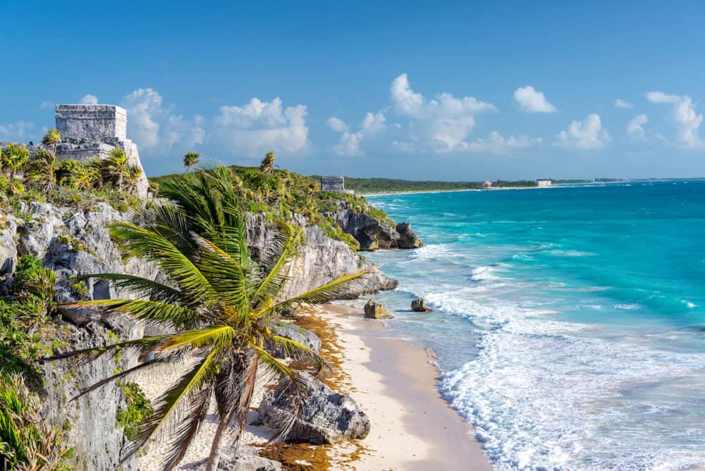 Ruins of Tulum Mexico and a palm tree overlooking the Caribbean Sea in the Riviera Maya