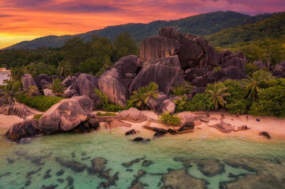Colorful sunset over Anse Source Dargent beach at the La Digue Island, Seychelles, with calm water of the Indian Ocean and amazing granite rock formations.