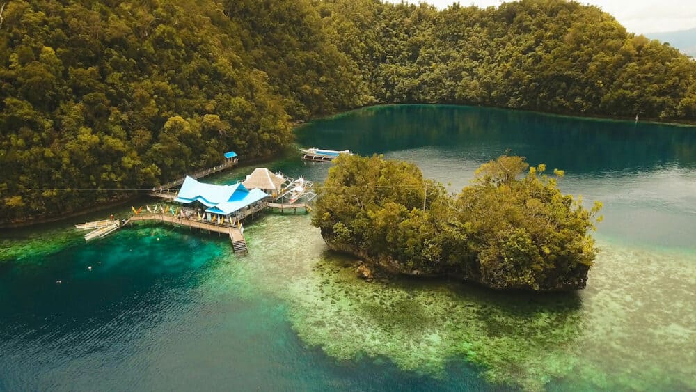 Aerial view: Bucas Grande Island, Sohoton Cove. Philippines. Tropical sea bay and lagoon, beach. Tropical landscape hill, clouds and mountains rocks with rainforest. Azure water of lagoon. Shore Landscape Bay. Aerial video.Seascape. Travel concept.