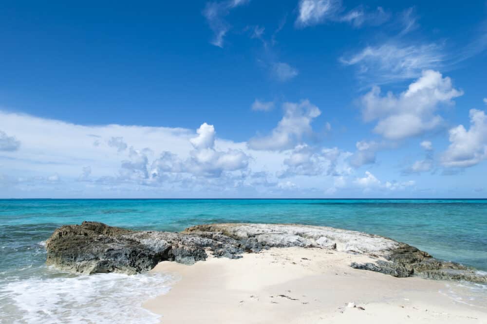 The scenic view of Grand Turk island beach with turquoise color waters and picturesque sky (Turks and Caicos Islands).