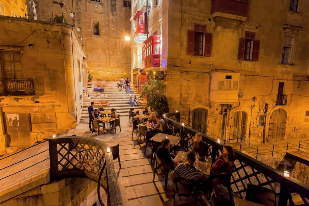 VALLETTA, MALTA: People having late dinner in restaurant on small stone bridge of historical city. Malta has more than 1.6 million tourists per year