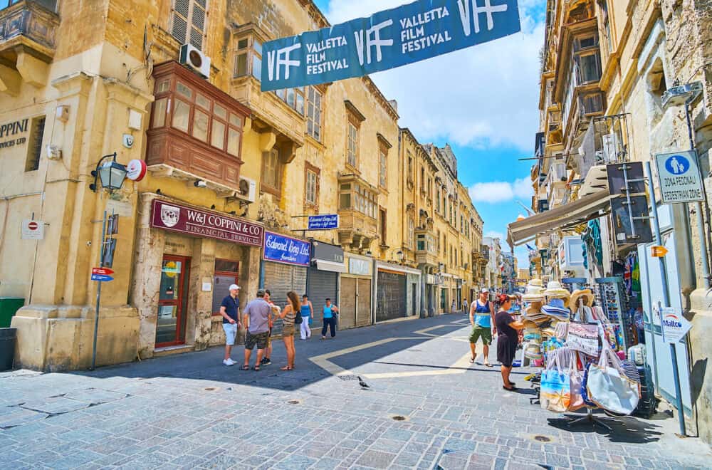 VALLETTA, MALTA - The souvenir shops, boutiques, workshops and cafes line historical Merchants street with preserved medieval edifices