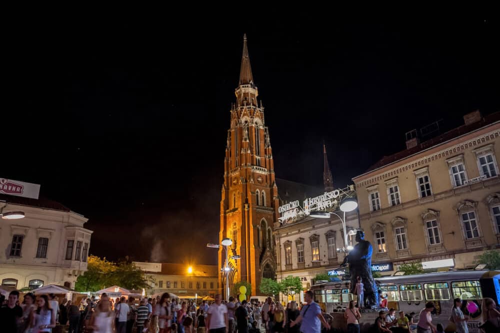 OSIJEK, CROATIA -  Crowd gathering at a food festival on the main square of Osijek, Ante Starcevic square. The Cathedral of the city can be seen in the background