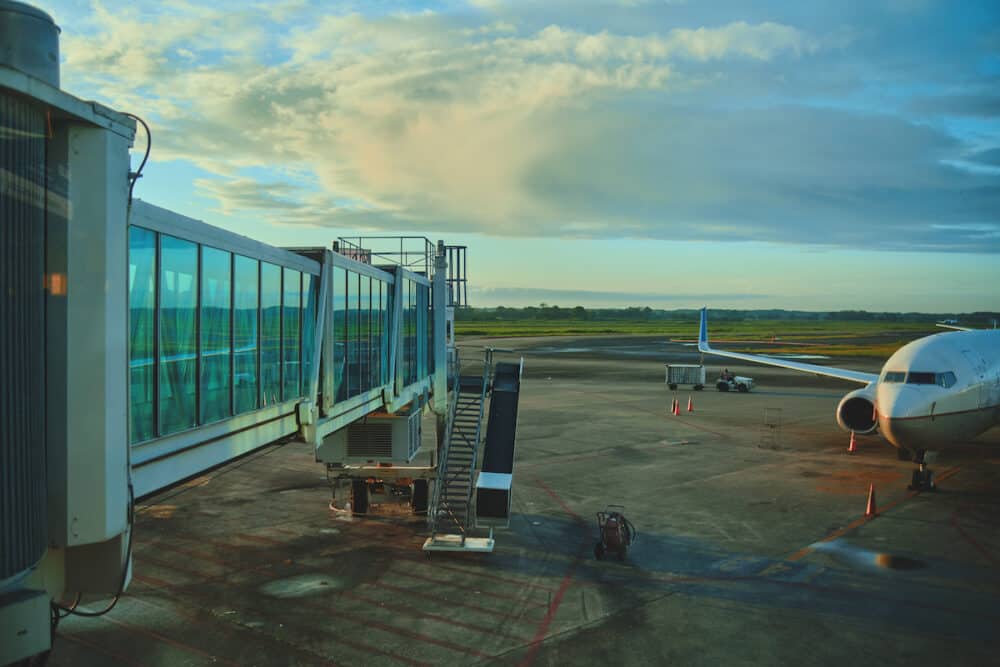Parked aircraft on City Panama airport through the gate window. Travel concept