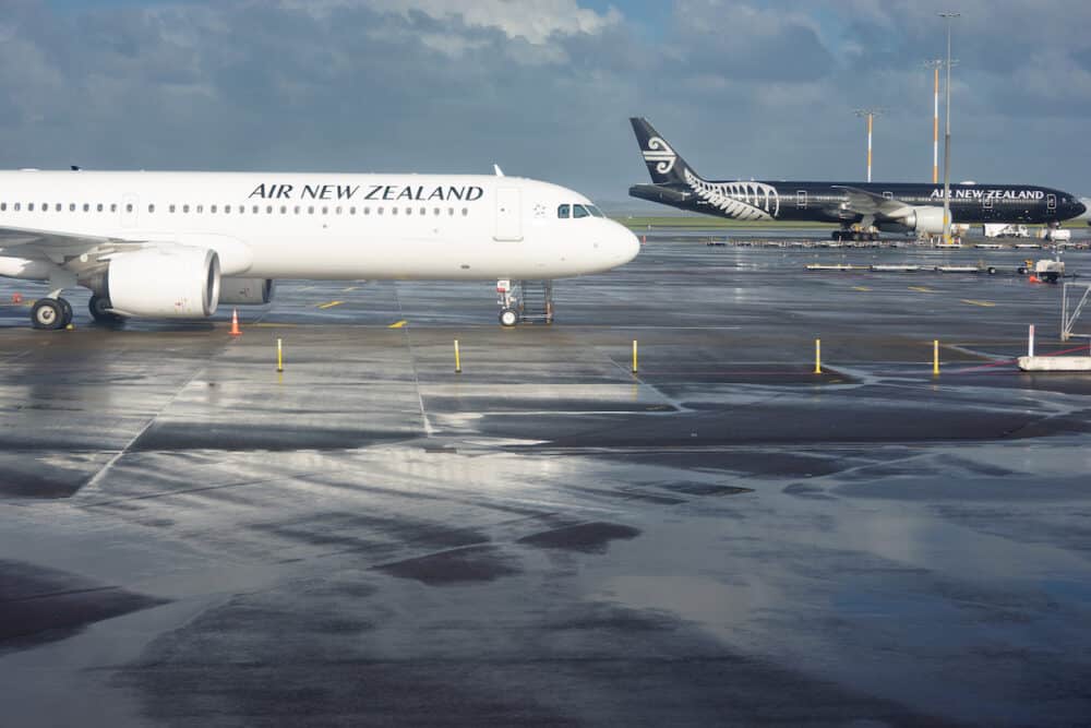 White and black Air New zealand planes parked on tarmac