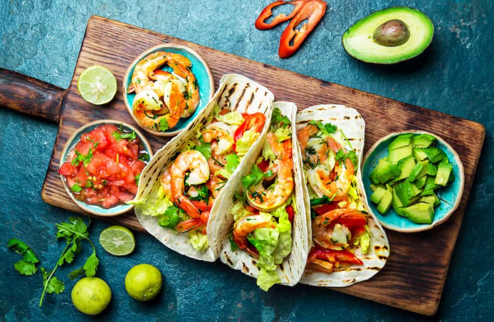 Shrimps tacos with salsa, vegetables and avocado. Mexican food.