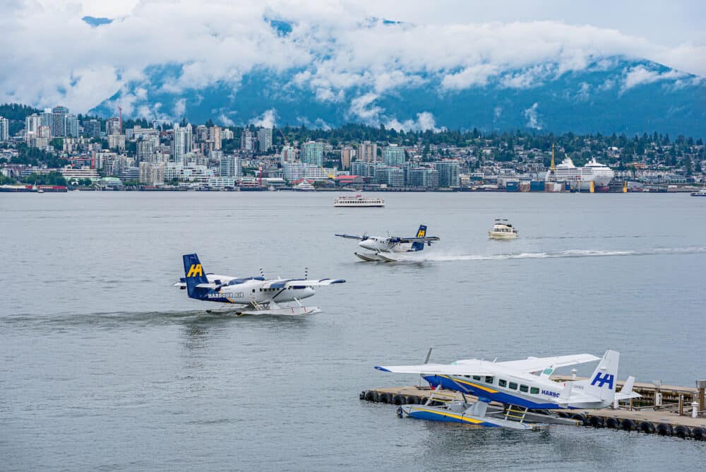 Boats and Harbour Air seaplanes in Coal Harbour with the North Vancouver, BC skyline in the background