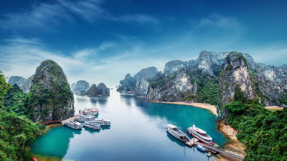 Tourist junks floating among limestone rocks at Ha Long Bay South China Sea Vietnam Southeast Asia