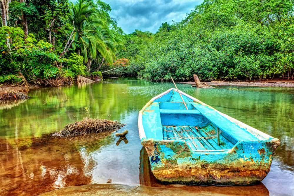 Old boat in tropical river, perfect place for fishing, exotic summer adventure, amazing nature of National Park of Costa Rica, Central America