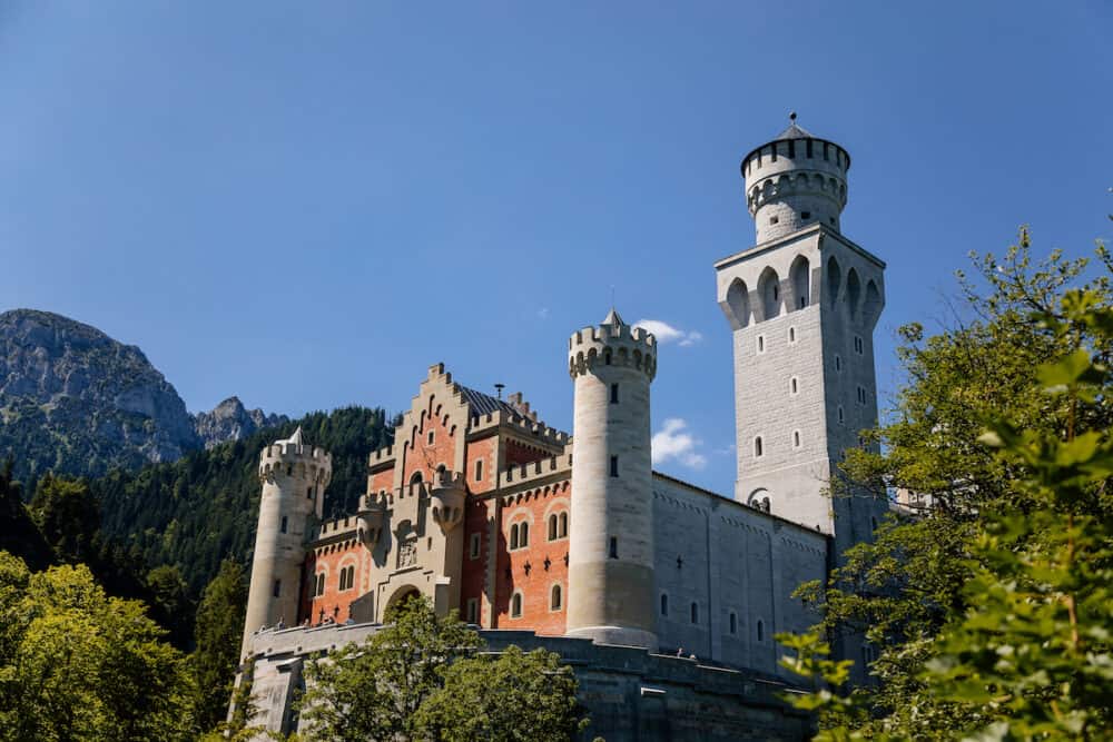 Neuschwanstein, Schwangau, Bavaria, Germany: famous tourist attraction in Alps, white castle with towers built by King Ludwig II, fairy tale schloss or chateau at sunny summer day