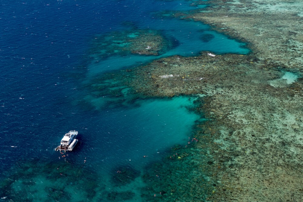 A tour boat pauses near the Great Barrier Reef to drop off groups of snorkelers.