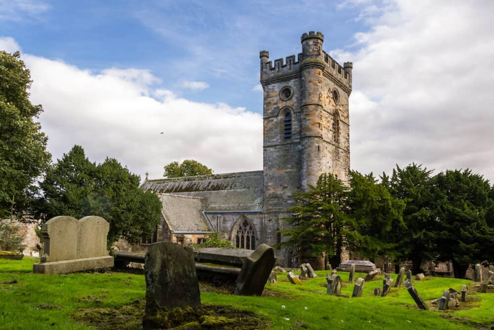 Culross, Scotland - Headstones in the Cemetery with Culross Abbey in the background in Dunfermline, Fife UK