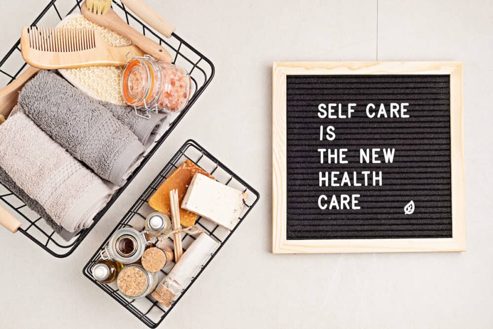 Self care is the new health care. Motivational quote on black letter board with variety of organic body and face care products. Natural homemade eco friendly beauty products concept. Flatlay, top view