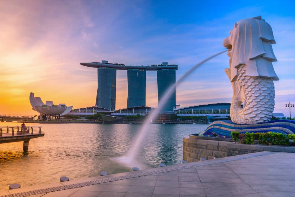 Merlion statue fountain in Merlion Park and Singapore city skyline at sunrise. Merlion fountain is one of the most famous tourist attraction in Singapore.