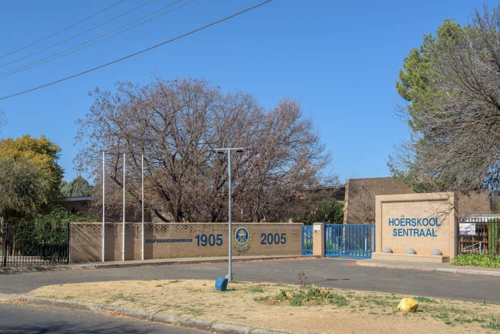BLOEMFONTEIN, SOUTH AFRICA - A street scene, with the Sentraal High School, in Dan Pienaar, a suburb of Bloemfontein. A centenary remembrance wall is visible.