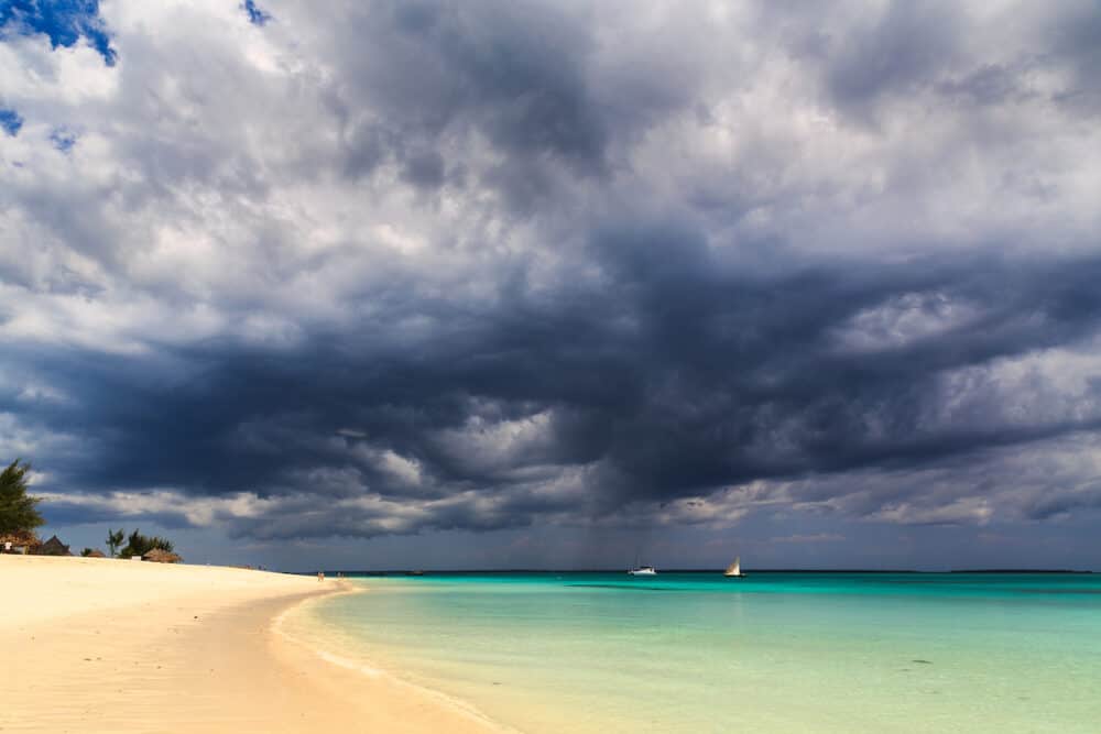 Dark storm clouds above a tropical beach with fishing boats