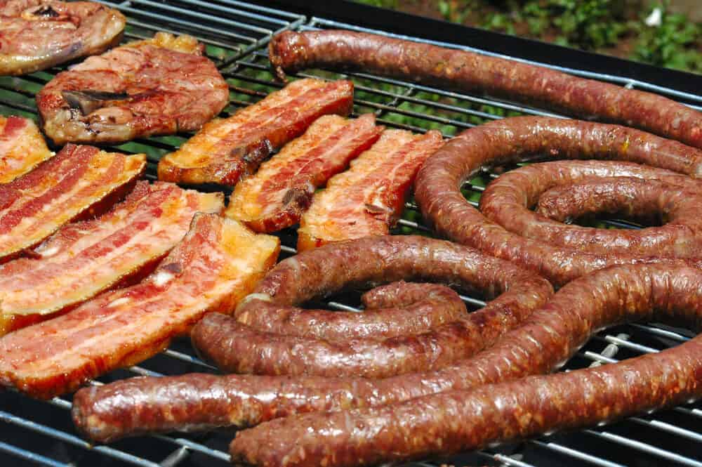 grilled pork meat lamb chops and sausages on a grill for a barbecue (south african braai) outdoors in south africa