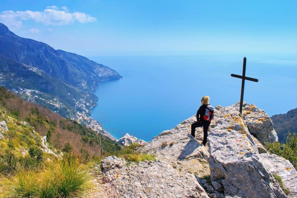 Woman hiker watching beautiful costal scenery - Path of the Gods "Sentiero degli Dei" the famous costal hiking trail, Amalfi Coast, Italy