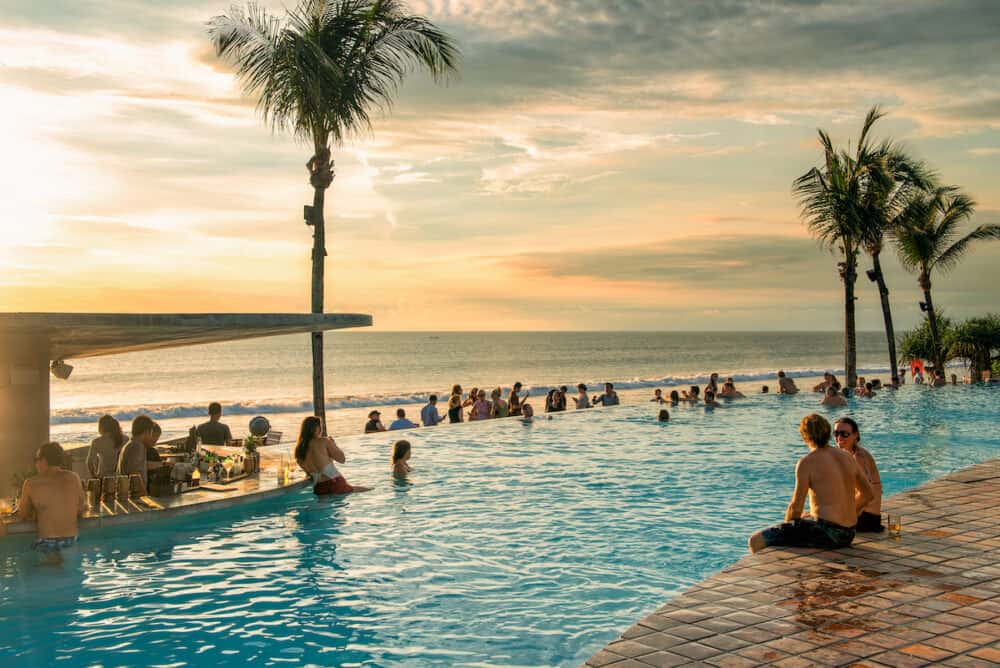 BALI, INDONESIA - Tourists enjoy a Bali vacation by the pool and beach. Bali is popular tourist destination in particular for Australian people.