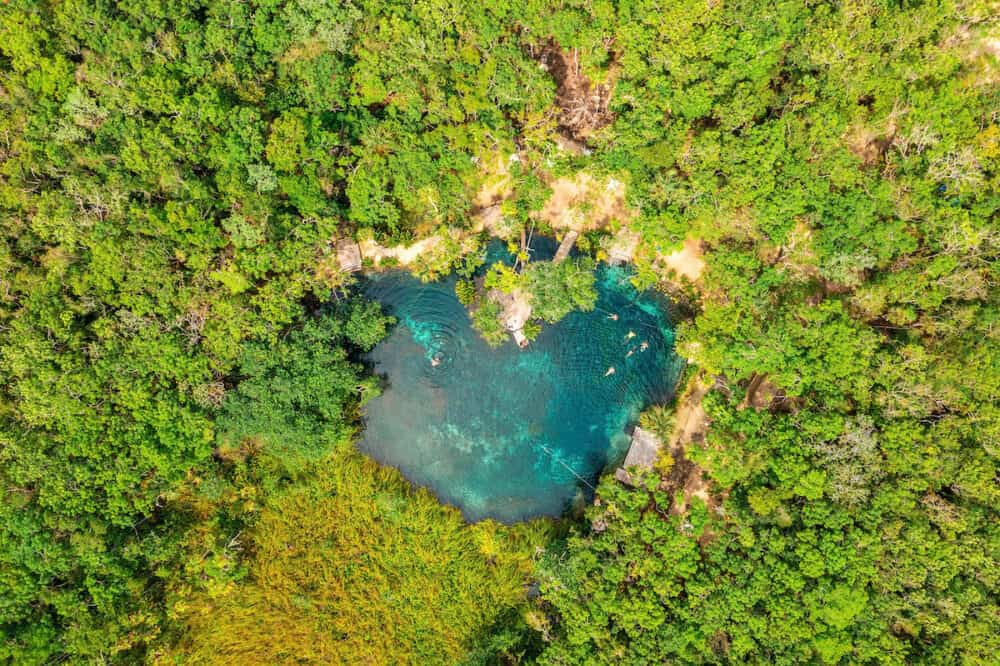 Heart shaped cenote in the middle of a jungle in Tulum, Mexico.