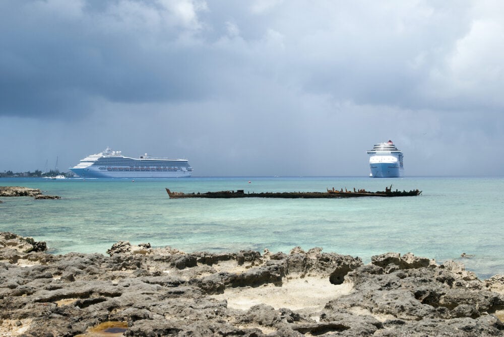 The view of two cruise ships drifting near George Town on Grand Cayman island and the remains of a sunken ship (Cayman islands).