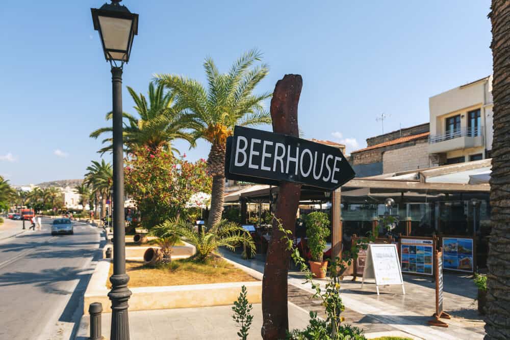 CRETE, GREECE -  Wooden street sign showing direction to beer house at street of Rethymno town