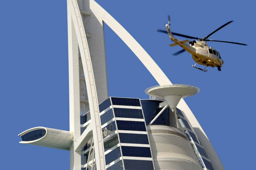 Dubai United Arab Emirates -  View of Burj Al Arab hotel with leaving helicopter from helicopter deck. Burj Al Arab is one of the Dubai landmark and one of the world's most luxurious hotels with 7 stars. 