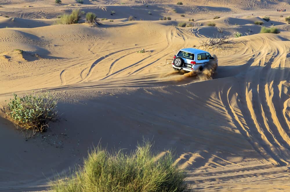rally off-road car 4x4 adventure driving safari on sand dunes on the desert