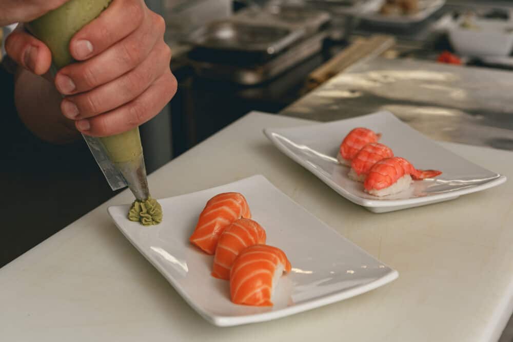 Close up of sushi master prepares sushi for serving in modern commercial kitchen