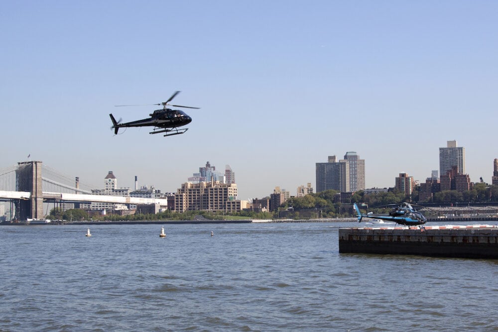 new york  -  helicopters take off and land along the east river in lower manhattan in new york city.