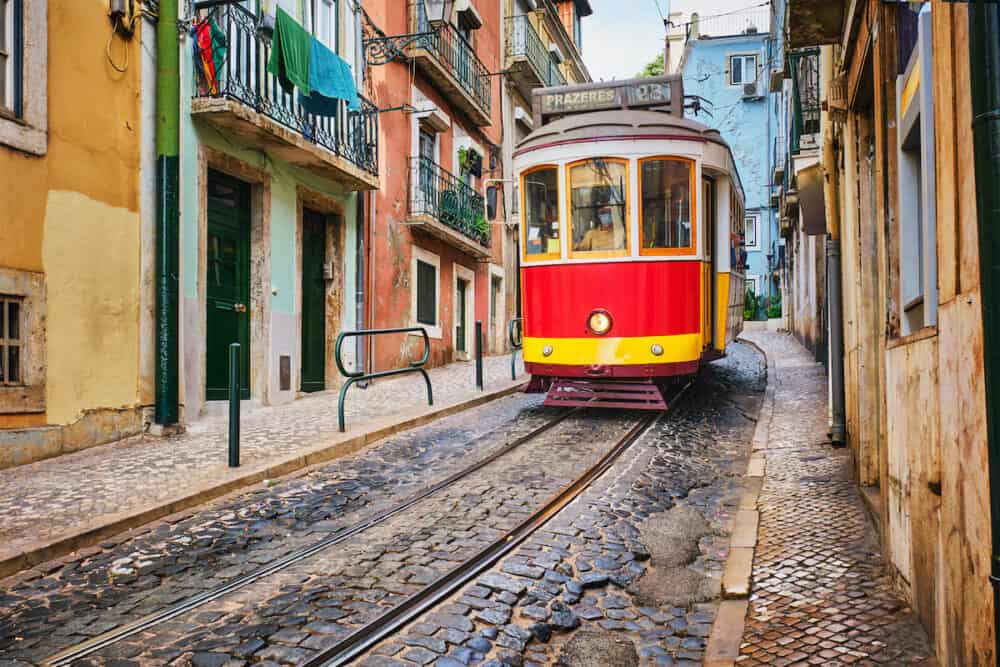 Famous vintage yellow tram 28 in the narrow streets of Alfama district in Lisbon, Portugal